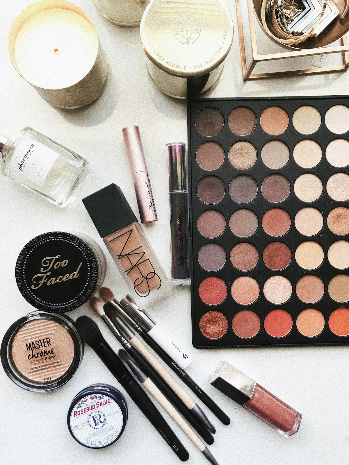 Beauty products including an eyeshadow palette, skincare and perfume.